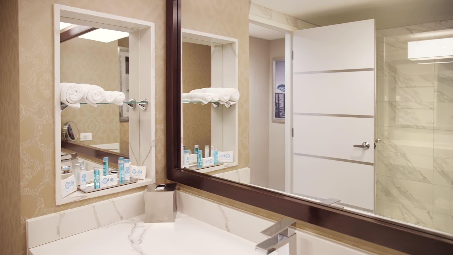 a hotel bathroom with a sink, mirror, and shower