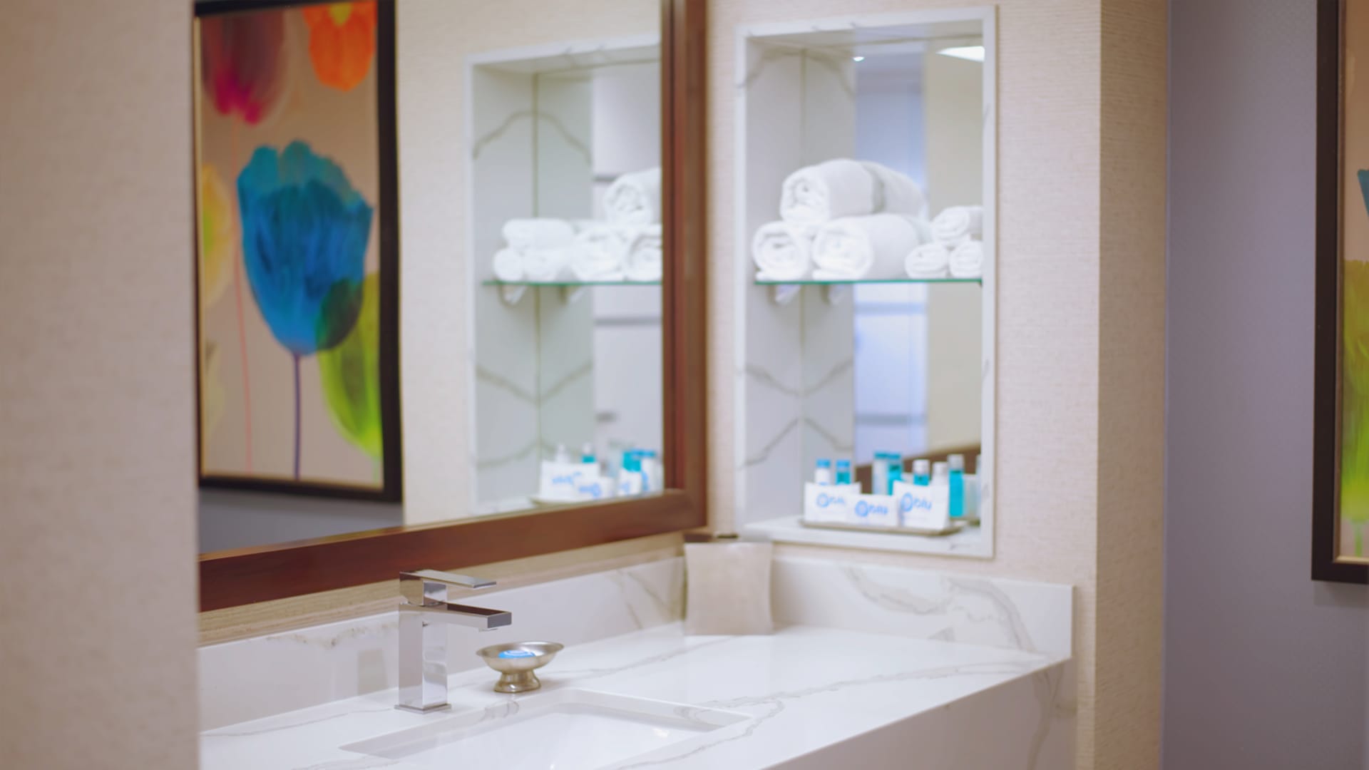 A bathroom sink with a marble countertop and a mirror above it.