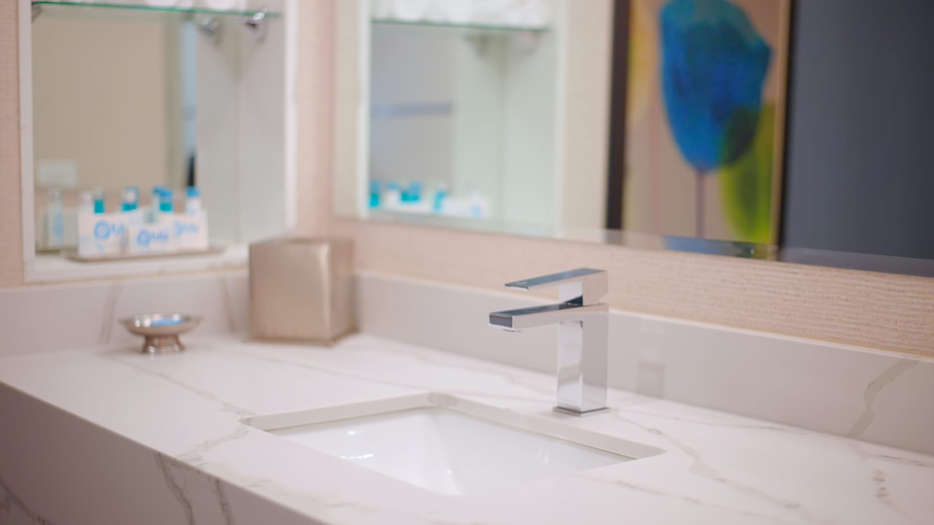 A close-up of a bathroom sink with a silver faucet and marble countertop