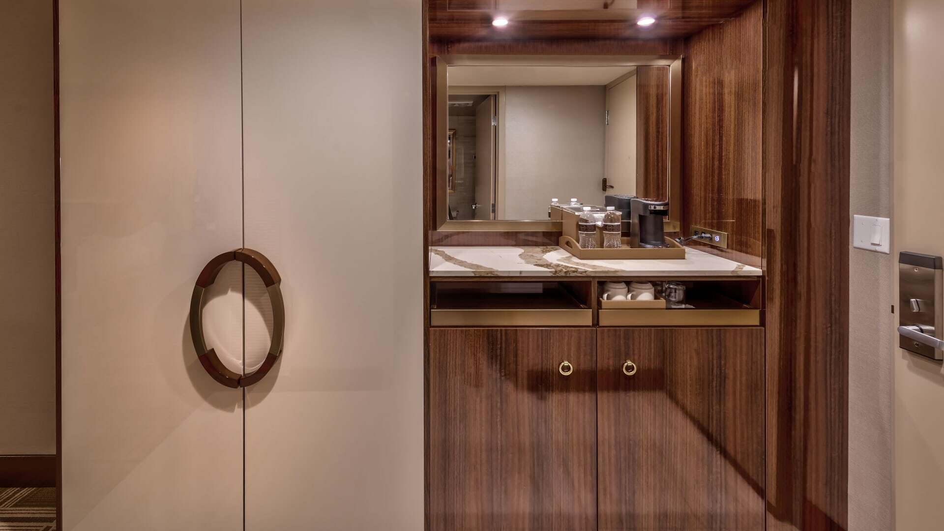 A bathroom countertop with a marble top, wood cabinets, and a mirror