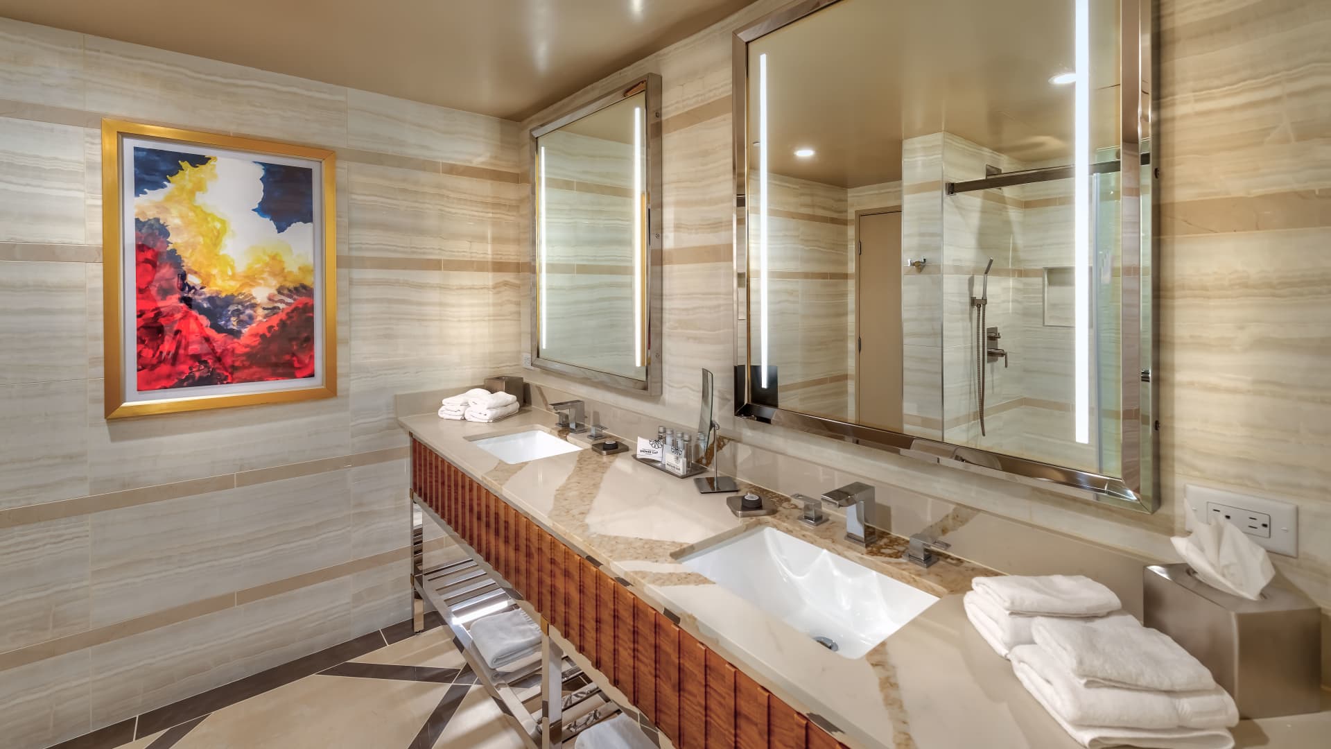 A luxurious bathroom with a double vanity, large mirror, and shower.