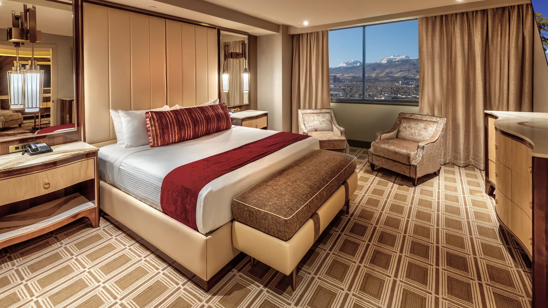A hotel room with a large bed, window, and seating area.