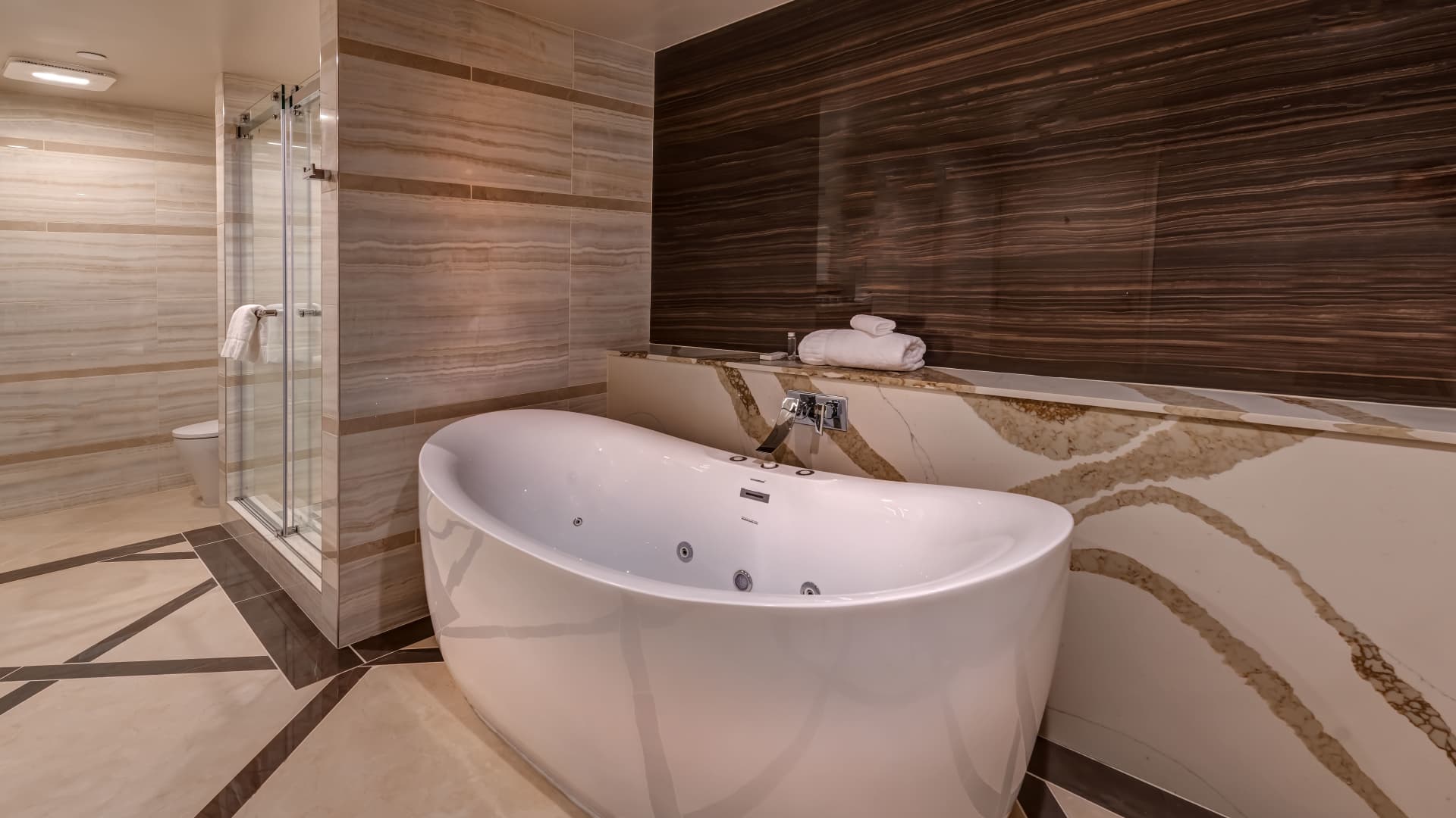 A luxurious bathroom with a large white bathtub and a glass-enclosed shower.