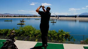 Photo of man completing a golf swing at Grand Bay Driving Range.
