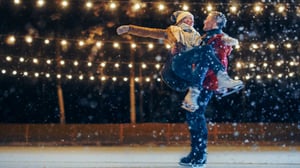 Man holding woman ice skating.